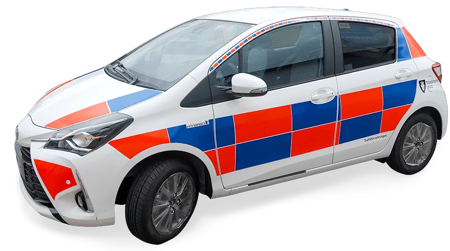 Orange och blått battenburgmönster i reflexvinyl på tjänstefordon i stad – typisk väghållningsprofil i Sverige.